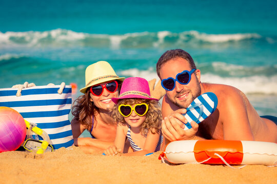 Happy family playing at the beach. Summer vacation concept