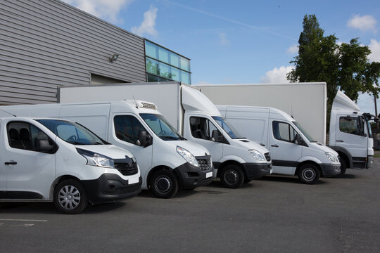 White Delivery Trucks Backed Up to A Warehouse Building