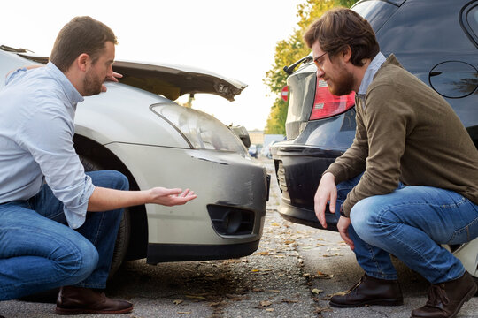 Two men arguing after a car accident on the road