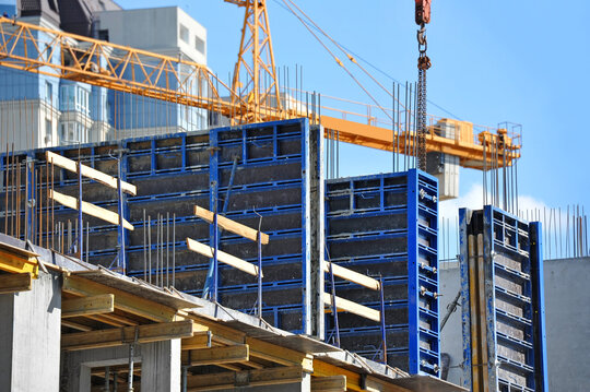 Crane and building under construction against blue sky