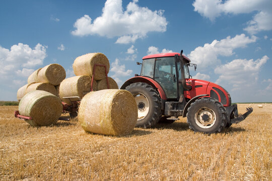 Agriculture - tractor on the field with harvested corn in haystack